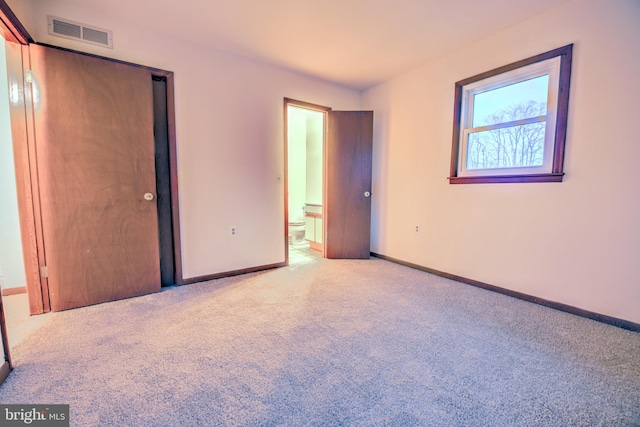 unfurnished bedroom with light carpet and a closet