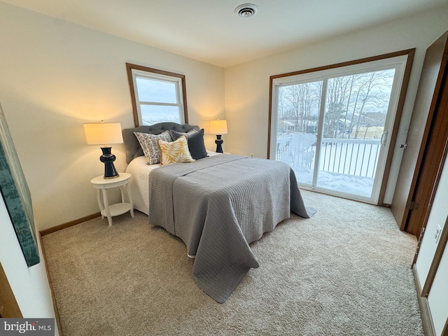 bedroom featuring access to exterior, light carpet, and multiple windows