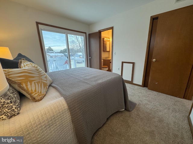 bedroom featuring ensuite bathroom and light colored carpet