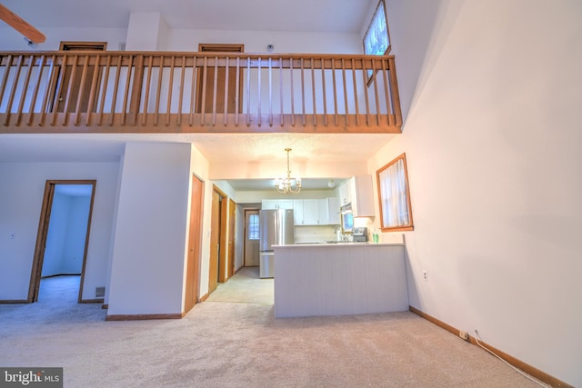 unfurnished living room featuring light colored carpet and a notable chandelier