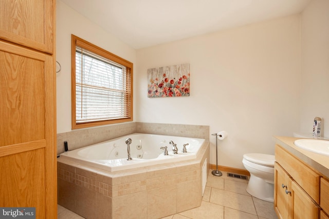 bathroom with tile patterned floors, tiled tub, vanity, and toilet