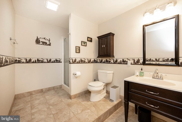 bathroom with vanity, toilet, and a shower with door