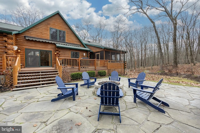 view of patio featuring a deck, an outdoor fire pit, and a sunroom