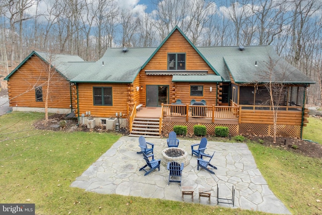 back of property featuring a yard, an outdoor fire pit, a patio area, and a wooden deck