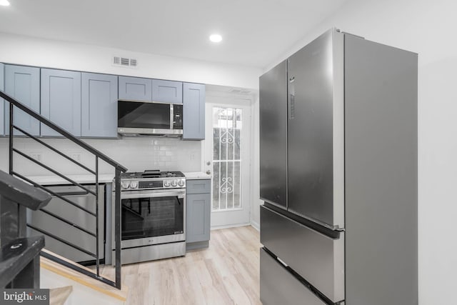 kitchen featuring decorative backsplash, stainless steel appliances, and light hardwood / wood-style floors