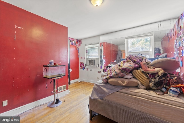 bedroom featuring light wood-type flooring and cooling unit