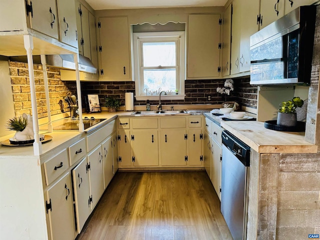 kitchen with backsplash, light wood-type flooring, sink, and appliances with stainless steel finishes