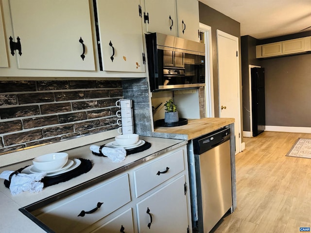 kitchen featuring tasteful backsplash, light hardwood / wood-style flooring, white cabinets, and stainless steel appliances