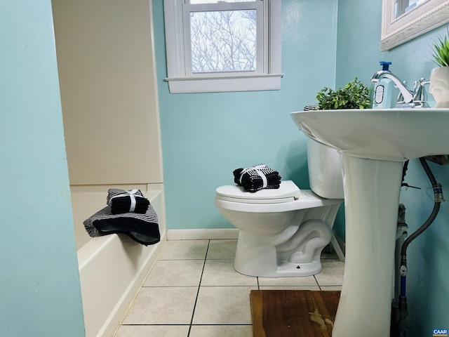 bathroom featuring toilet, tile patterned floors, and a bathtub