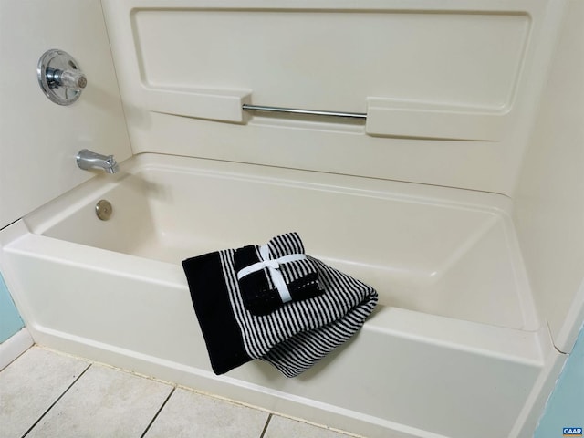 bathroom with tile patterned flooring and a bath