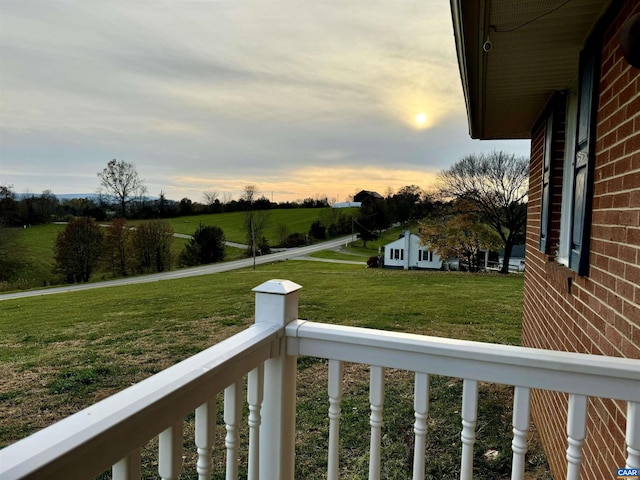 yard at dusk featuring a rural view