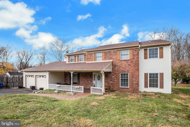 view of front of property featuring a garage, covered porch, and a front lawn