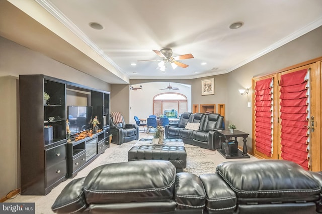 carpeted living room featuring ceiling fan and crown molding