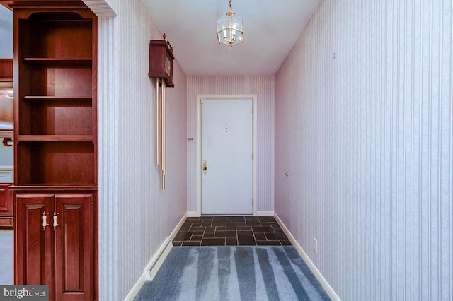 entryway with built in shelves and dark tile patterned flooring