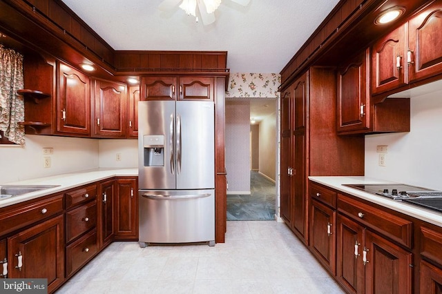 kitchen with stainless steel refrigerator with ice dispenser, black cooktop, ceiling fan, and sink