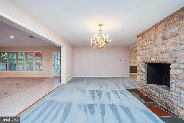 unfurnished living room with carpet flooring, a stone fireplace, and a notable chandelier