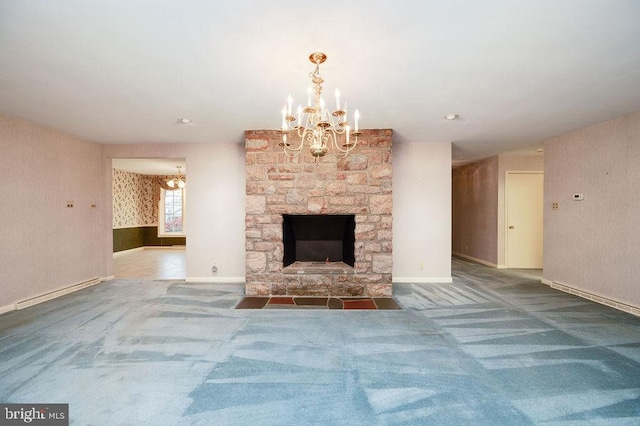 unfurnished living room with carpet flooring, a stone fireplace, a baseboard heating unit, and a notable chandelier