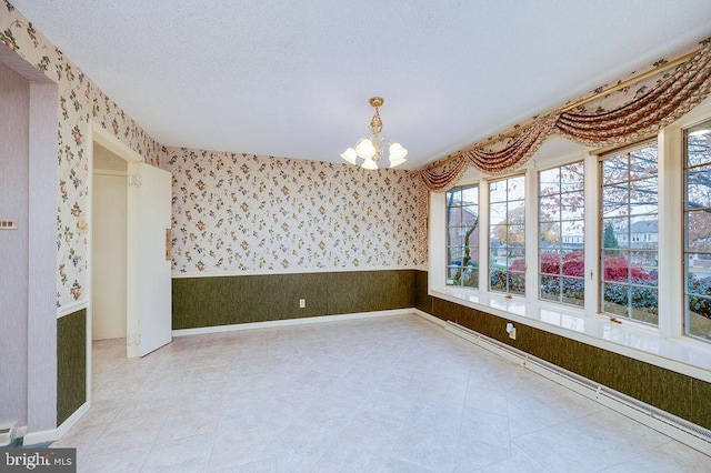 unfurnished room with a chandelier and a textured ceiling