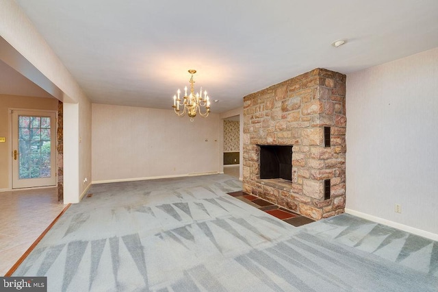 unfurnished living room featuring a chandelier, carpet flooring, and a stone fireplace