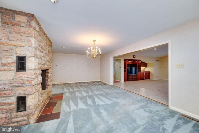 unfurnished living room with carpet, a fireplace, and a chandelier