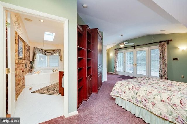 bedroom with vaulted ceiling with skylight, carpet floors, and multiple windows