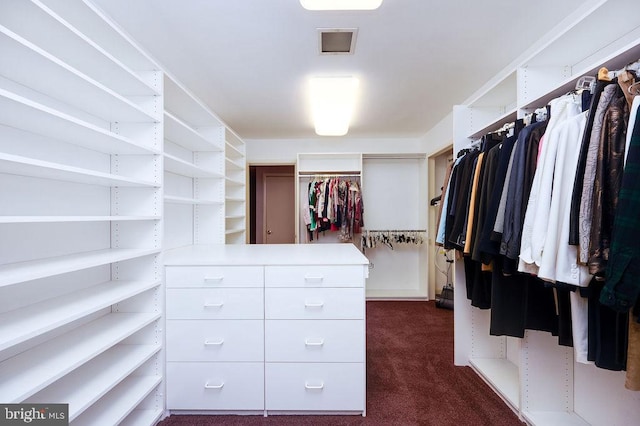 walk in closet featuring dark carpet