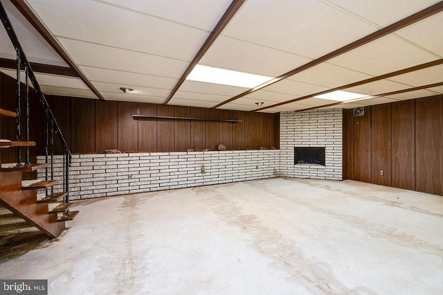 basement featuring a fireplace and wooden walls