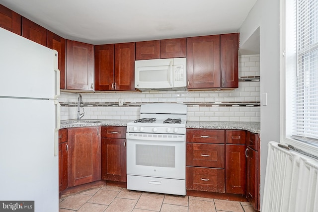 kitchen with decorative backsplash, white appliances, radiator, and sink