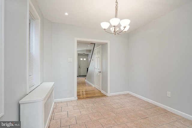 unfurnished dining area with light wood-type flooring and a chandelier