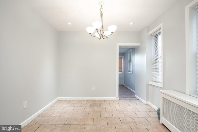 unfurnished room with an inviting chandelier, radiator, and light tile patterned flooring