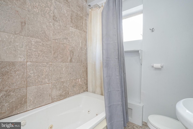 bathroom featuring toilet and shower / bath combo with shower curtain