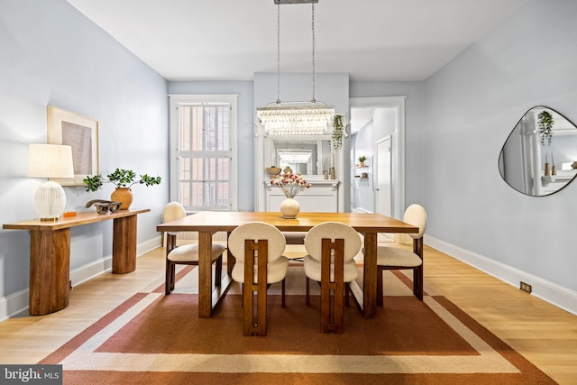 dining room with an inviting chandelier and light hardwood / wood-style flooring