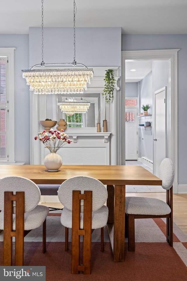 dining space with hardwood / wood-style flooring and an inviting chandelier