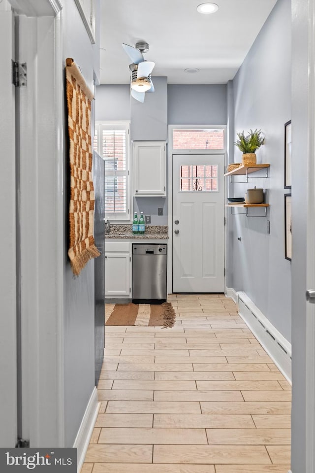 kitchen featuring white cabinetry, dishwasher, a baseboard heating unit, and light wood-type flooring