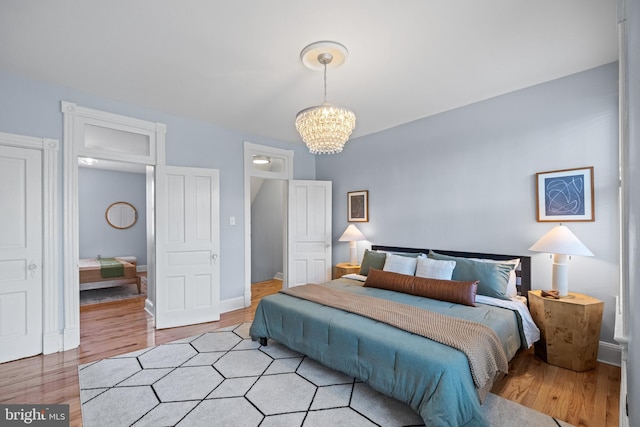 bedroom with a chandelier and light hardwood / wood-style flooring