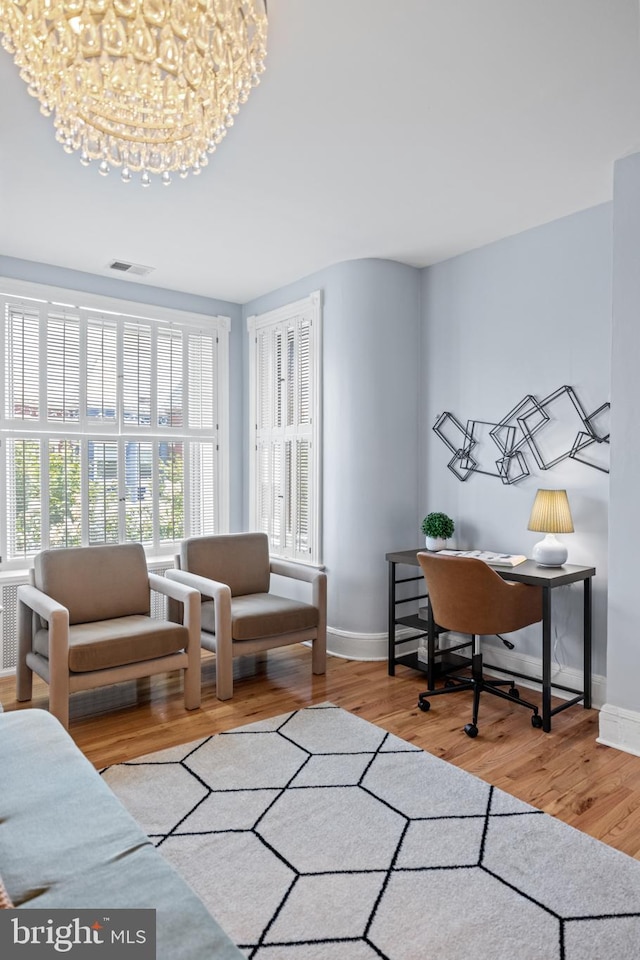 office area with light hardwood / wood-style flooring and a chandelier