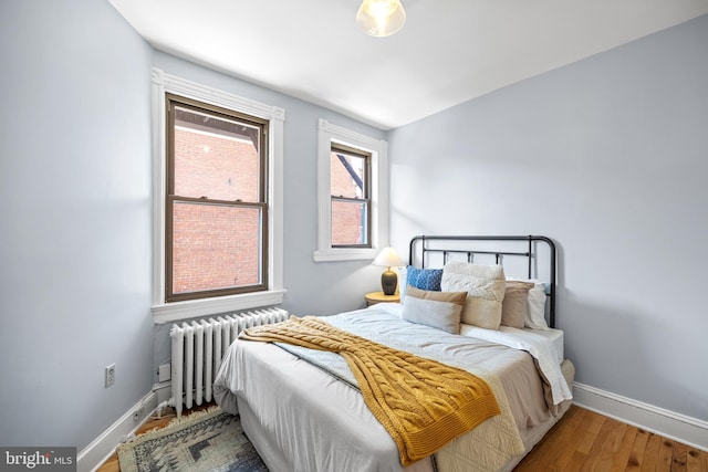 bedroom with hardwood / wood-style flooring and radiator