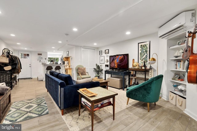 living room with a wall unit AC and light wood-type flooring