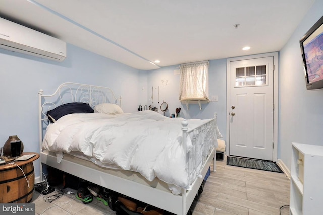 bedroom featuring a wall mounted air conditioner and light wood-type flooring