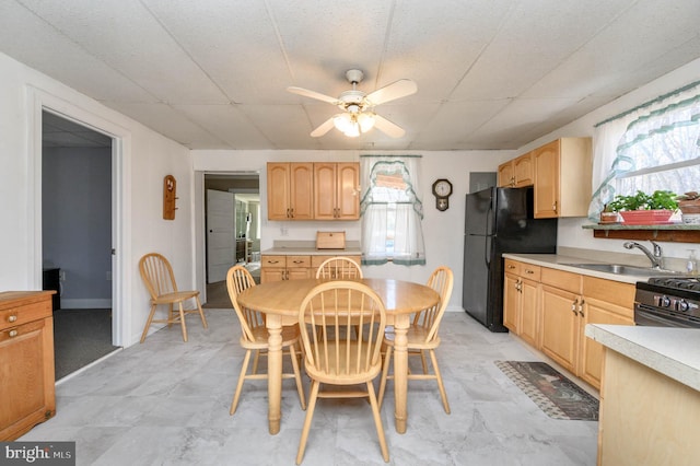 dining space featuring ceiling fan and sink