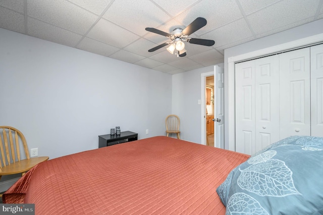 bedroom featuring a paneled ceiling, ceiling fan, and a closet