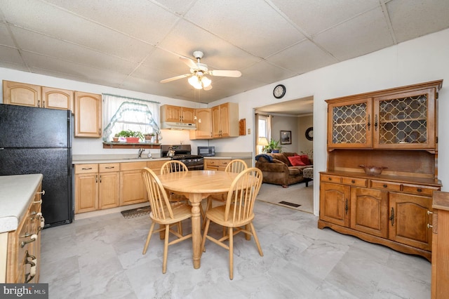 dining space featuring ceiling fan, a drop ceiling, and sink