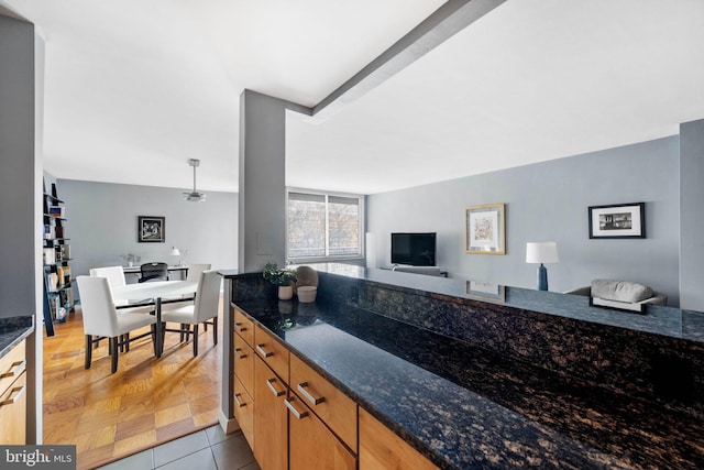 kitchen with pendant lighting, light parquet floors, and dark stone countertops