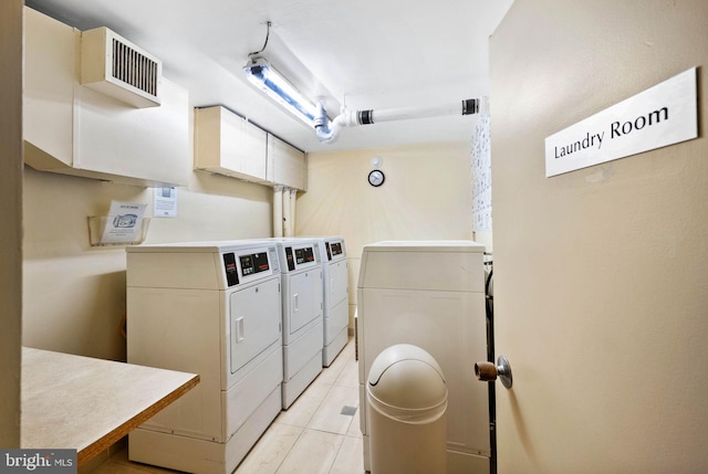 laundry area featuring washing machine and dryer and light tile patterned flooring