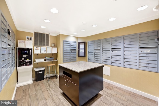 kitchen featuring dark brown cabinetry, mail boxes, light hardwood / wood-style floors, a kitchen island, and ornamental molding