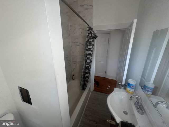 bathroom with hardwood / wood-style floors and shower / tub combo with curtain