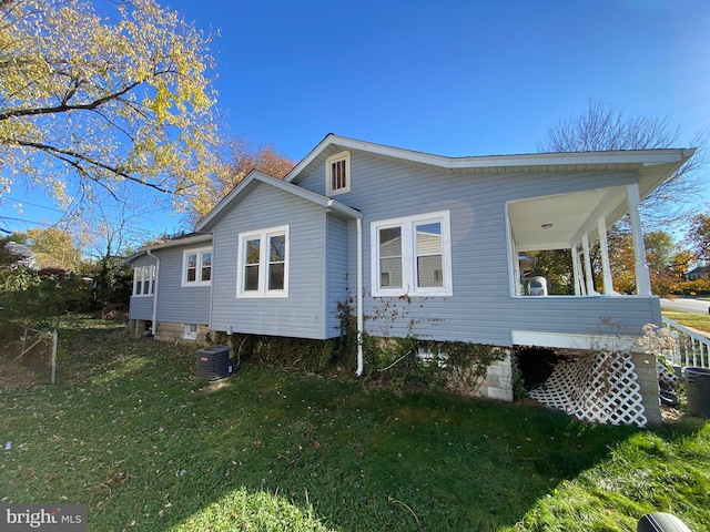 view of side of property with central AC unit and a lawn