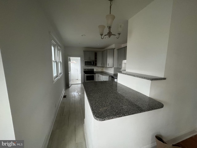 kitchen with kitchen peninsula, appliances with stainless steel finishes, light hardwood / wood-style floors, and gray cabinetry