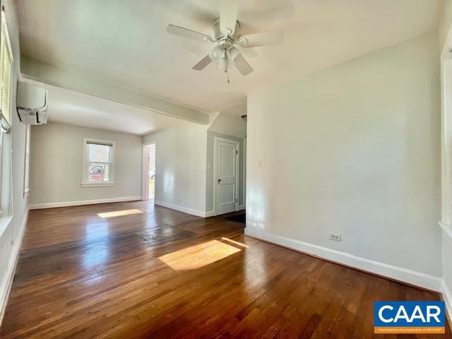 spare room with a wall mounted air conditioner, ceiling fan, and dark wood-type flooring