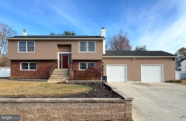 bi-level home featuring solar panels and a garage